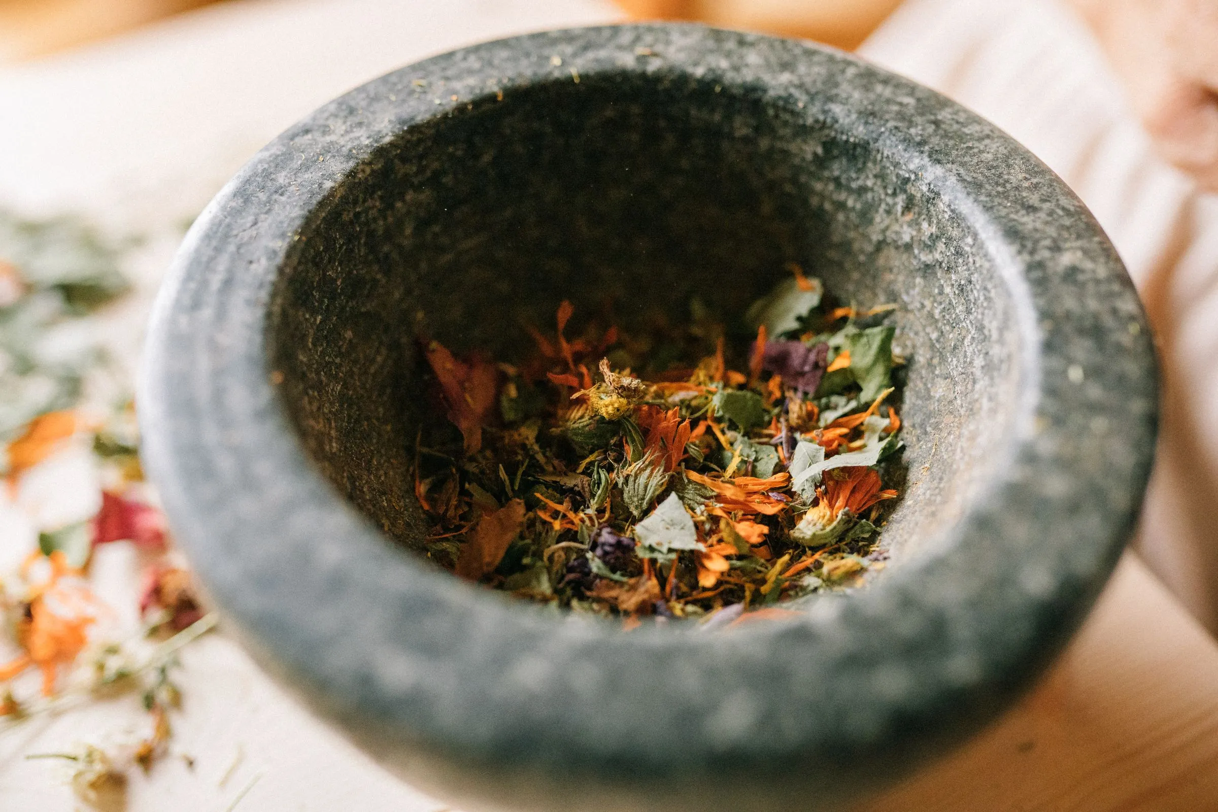 Herbs being ground with a stone mortar and pestle