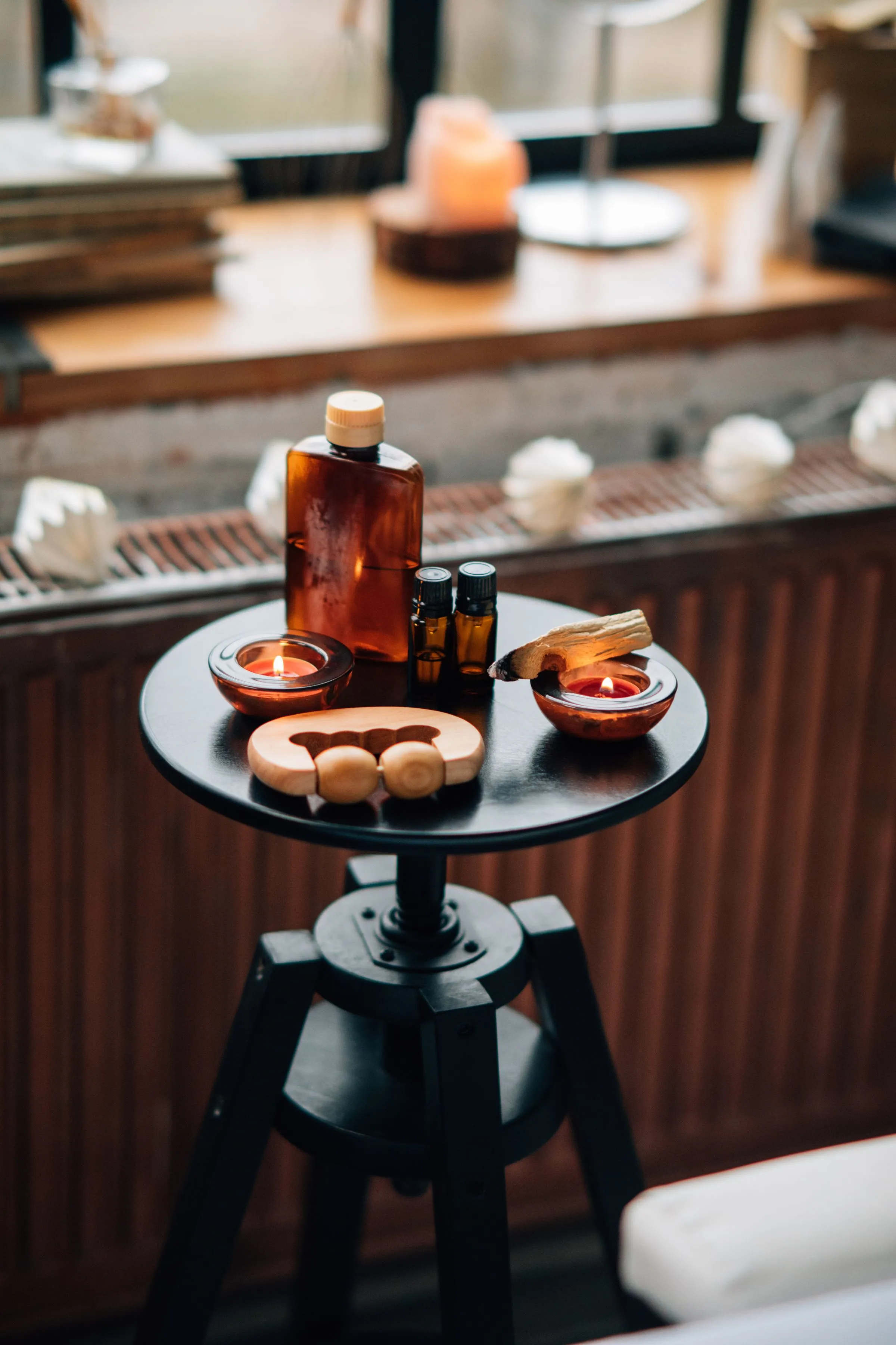 Warm medicated oil, candles and palo santo on a low table